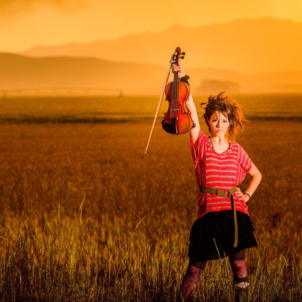Скрипачка Линдси Стирллинг стоит в поле