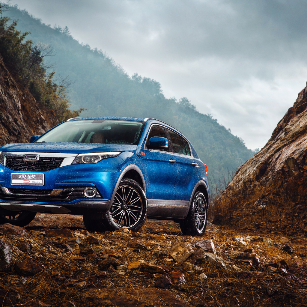 Синий китайский автомобиль Qoros 5  под дождем