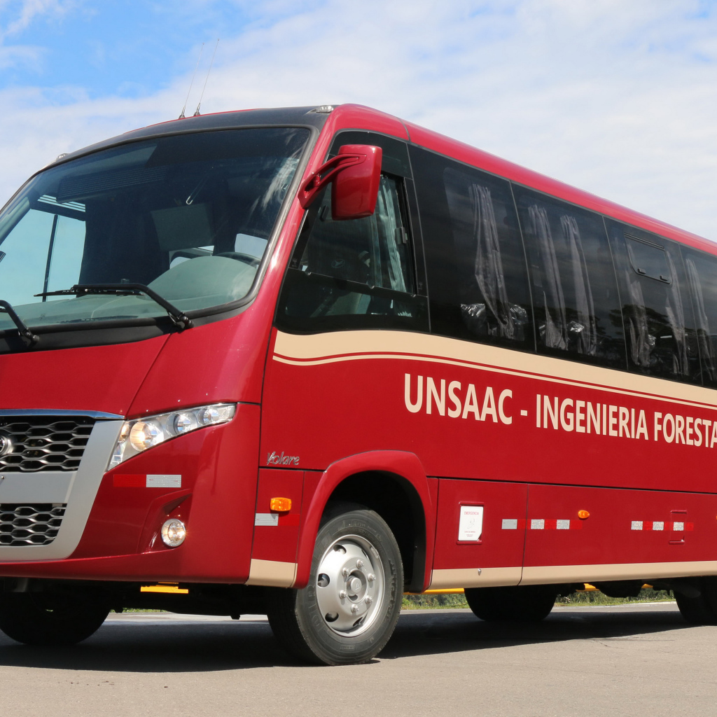 Красный автобус Volare W9 Executivo на дороге