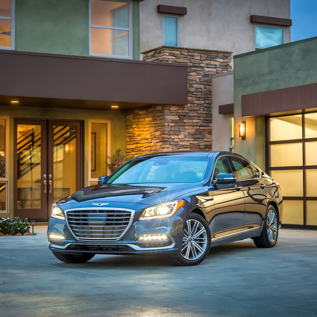 Серебристый автомобиль Genesis G80 с включенными фарами