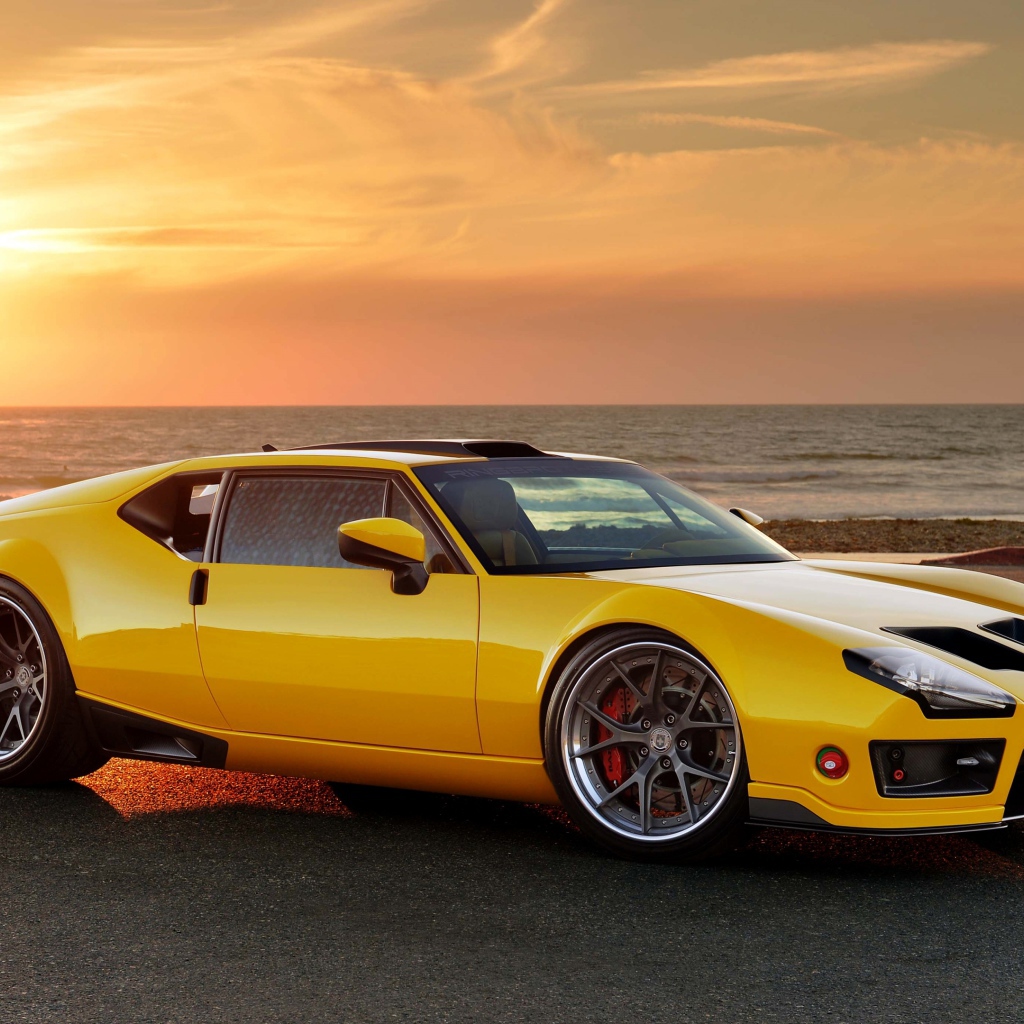 Желтый спортивный автомобиль De Tomaso Pantera на фоне заката
