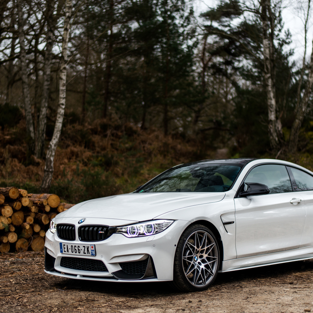 White stylish BMW M4 car on the background of trees