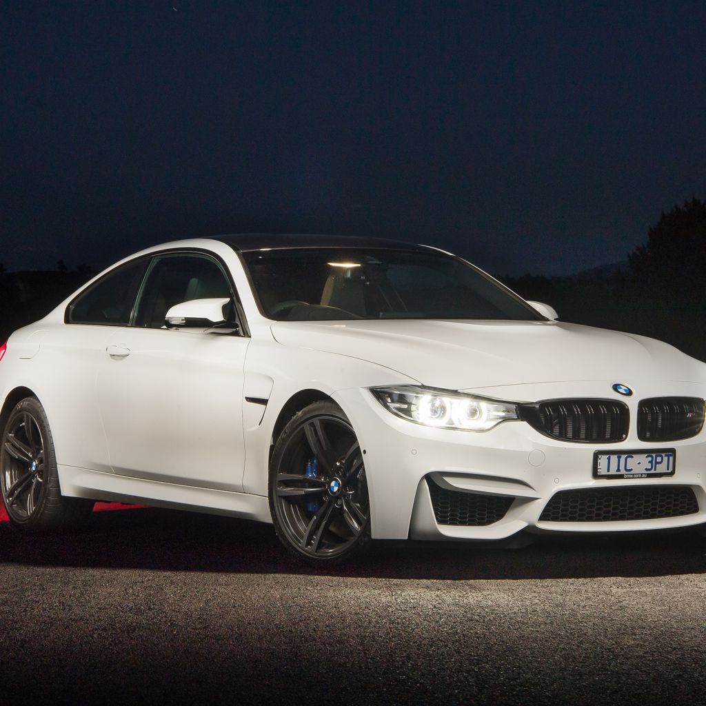 Белый автомобиль BMW M4 Coupe Pure Edition с включенными фарами