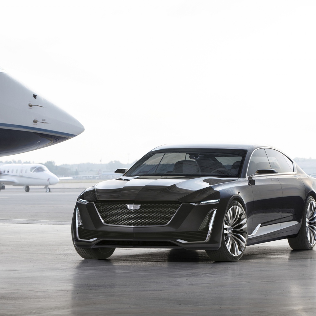 Черный стильный автомобиль Cadillac Escala на фоне самолетов