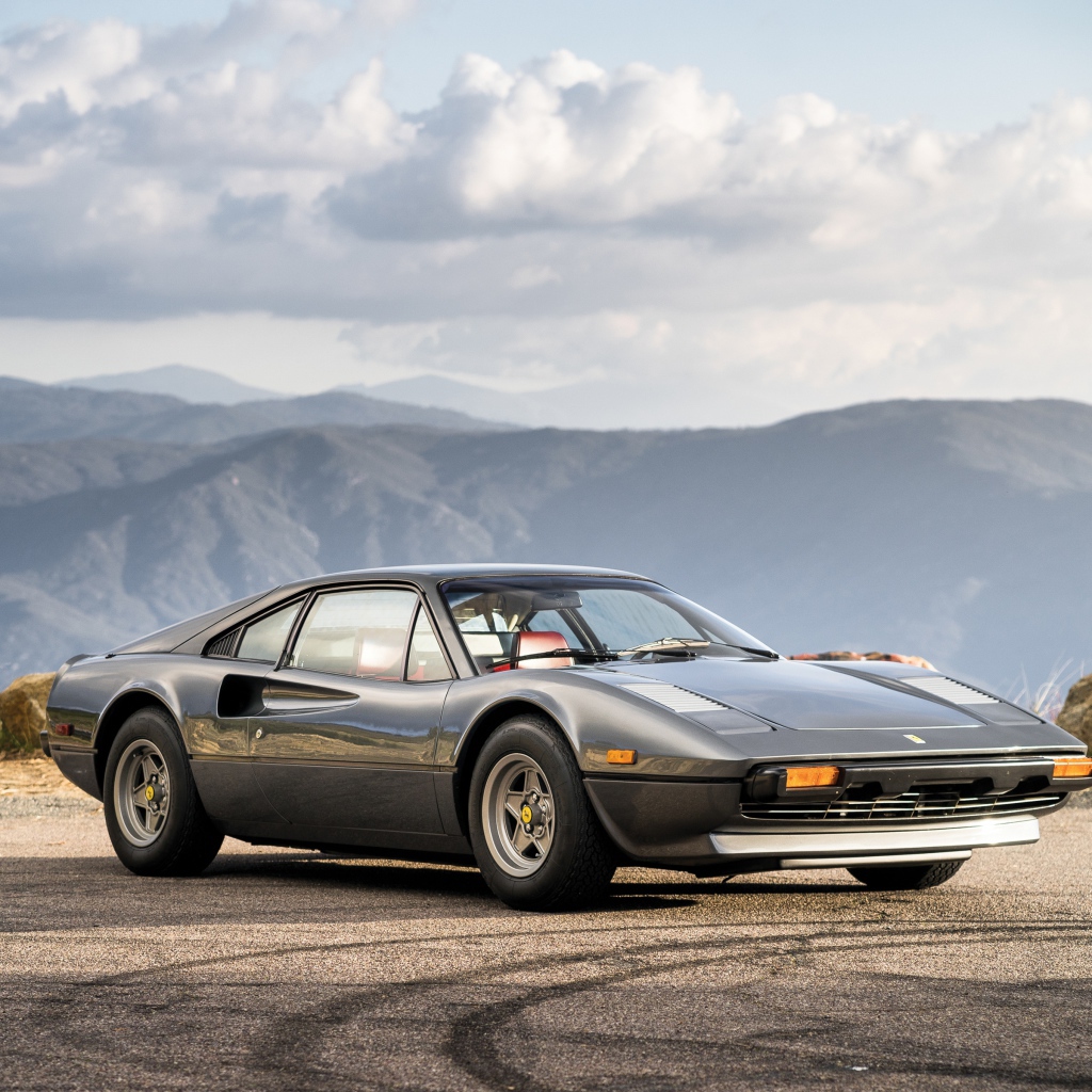 Суперкар Ferrari 308 gts серого цвета,   на фоне гор 