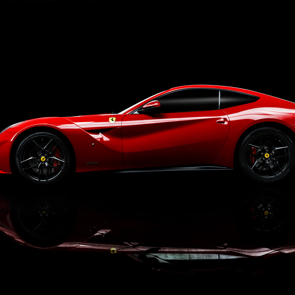 Красный спортивный автомобиль Ferrari F12 berlinetta на черном фоне