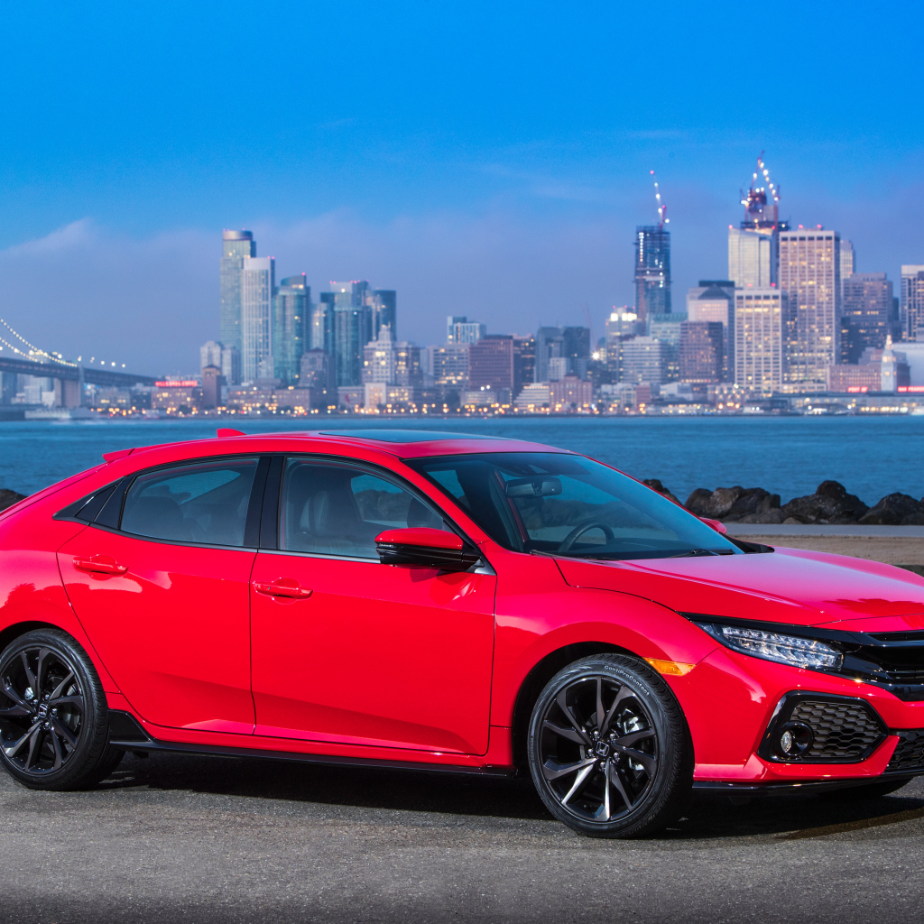 Красный автомобиль Honda Civic Touring Hatchback, 2017 на фоне города 