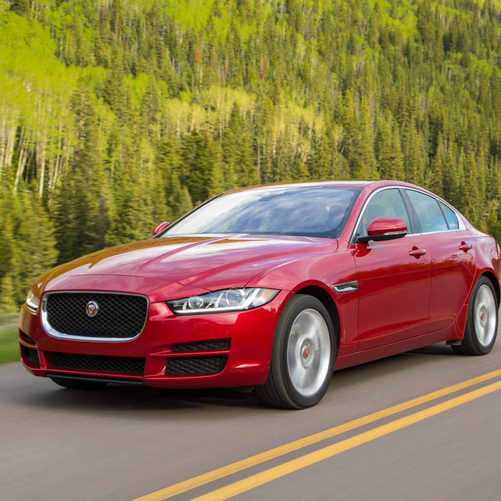 Автомобиль красного цвета Jaguar XE на трассе 