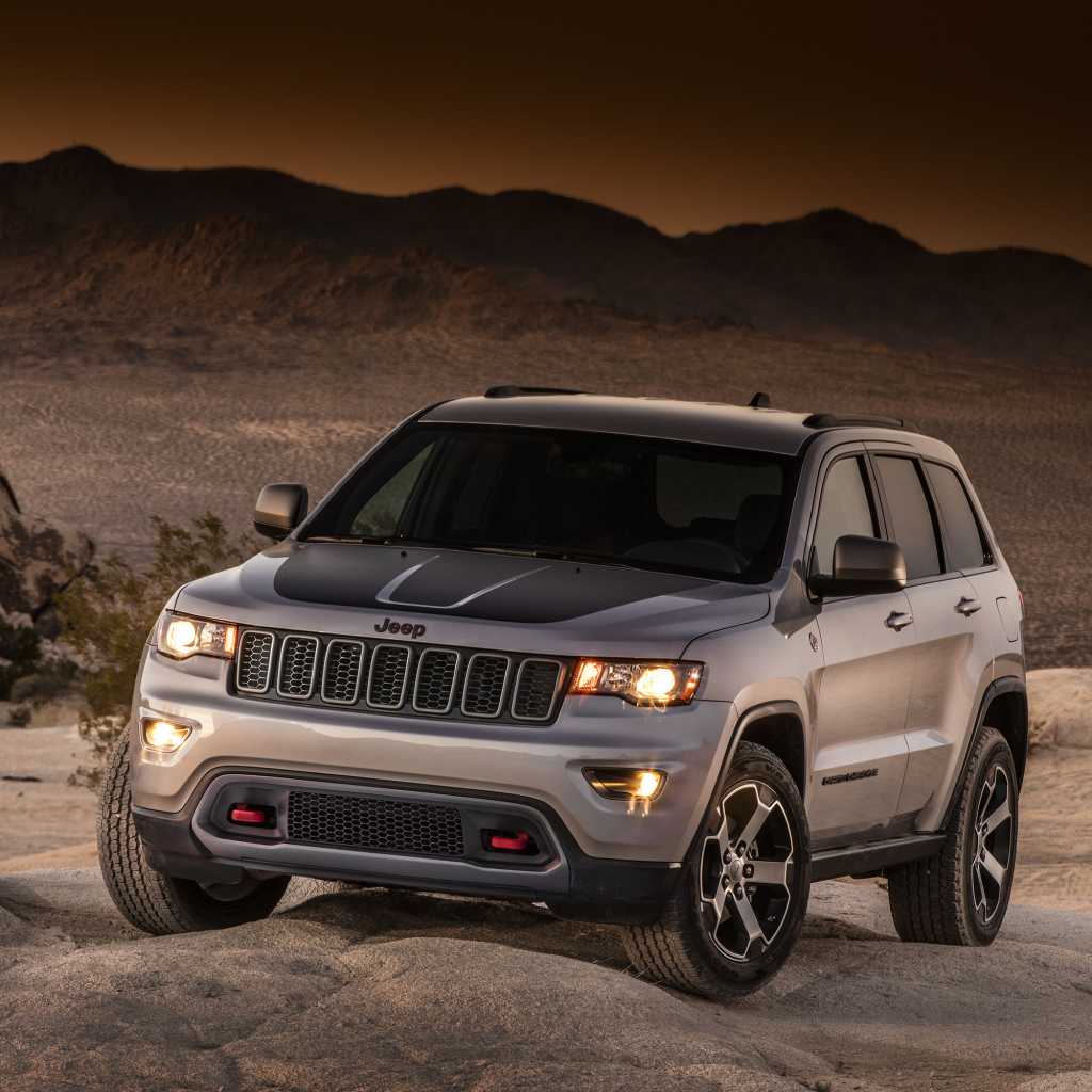 Серебристый внедорожник Jeep Grand Cherokee в пустыне 