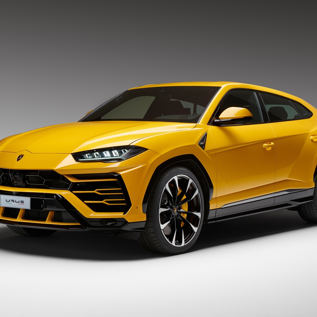 Желтый спортивный автомобиль Lamborghini Urus, 2018 на сером фоне