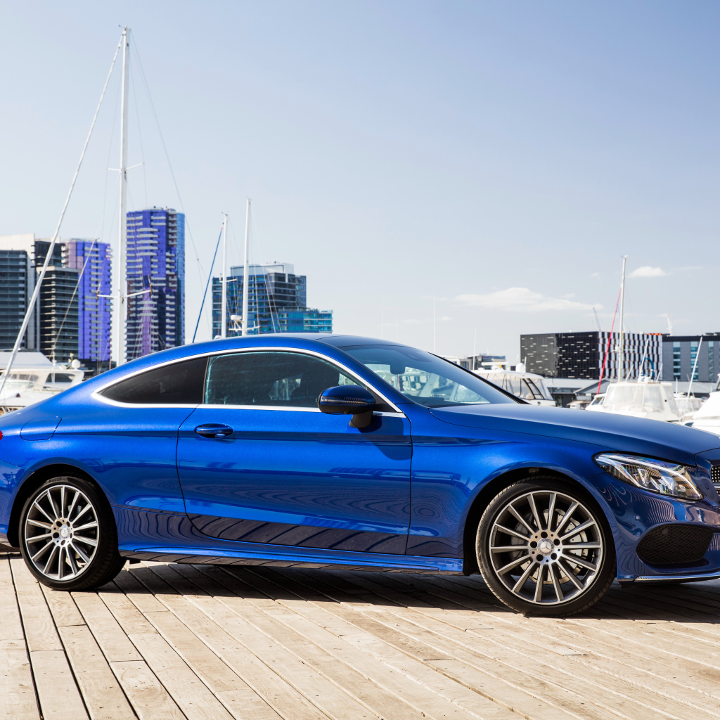 Синий автомобиль Mercedes-Benz C205 на фоне города