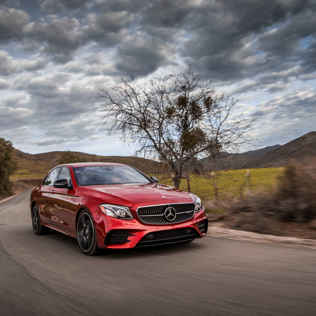 Стильный красный автомобиль Mercedes-Benz E-Class на фоне неба 