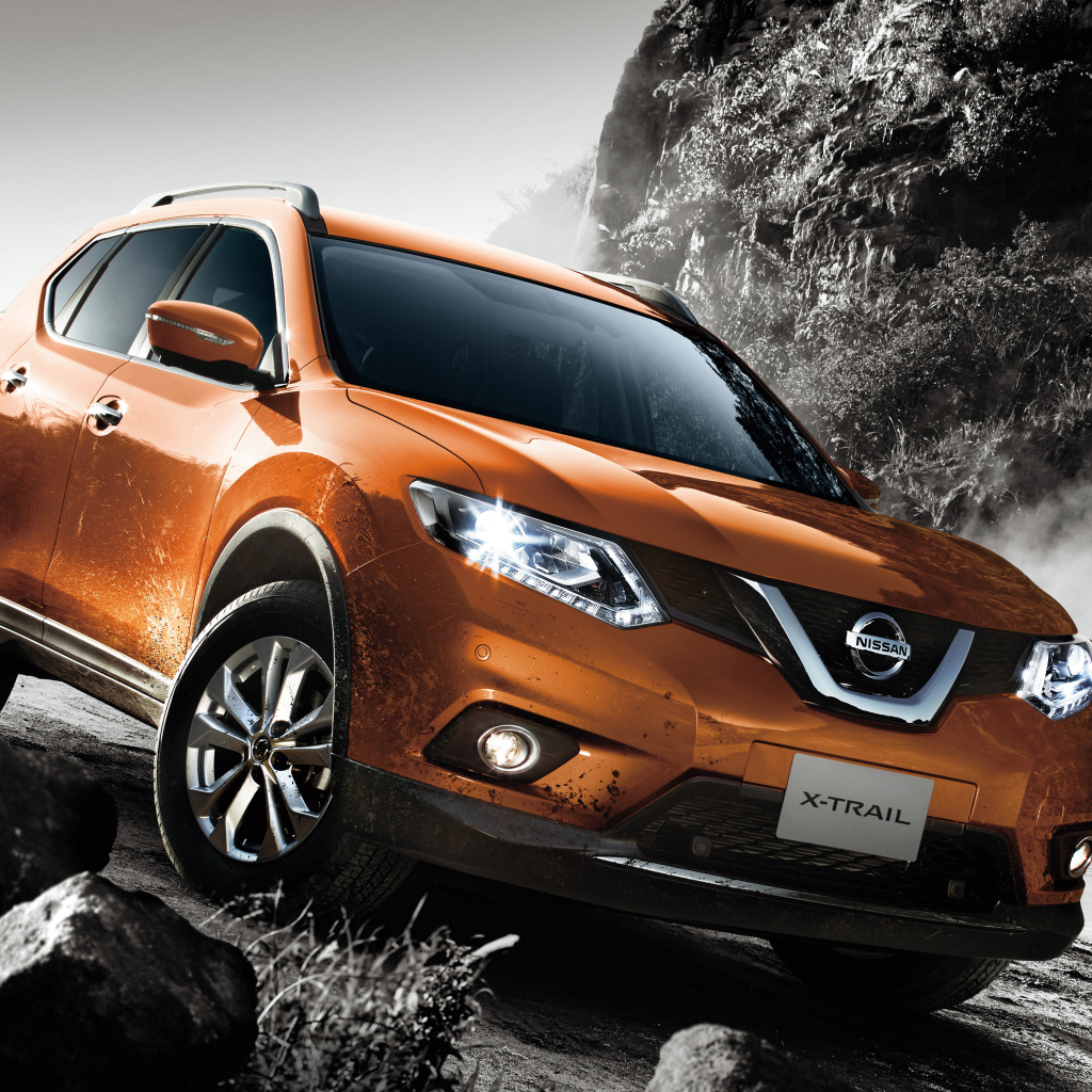 Оранжевый автомобиль Nissan X-Trail на размытой дороге 