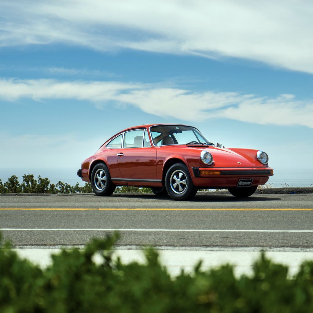 Красный автомобиль Porsche 912 на фоне голубого неба 