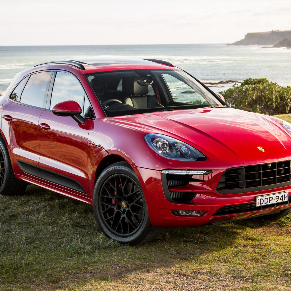 Красный автомобиль Porsche Macan,2017 на фоне океана 