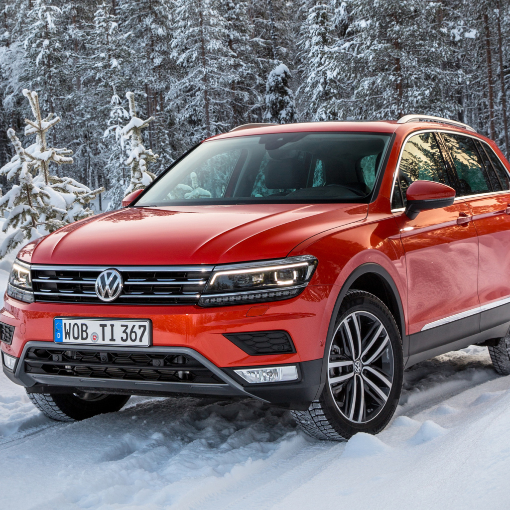Красный Volkswagen Tiguan 2017 года в заснеженном лесу 
