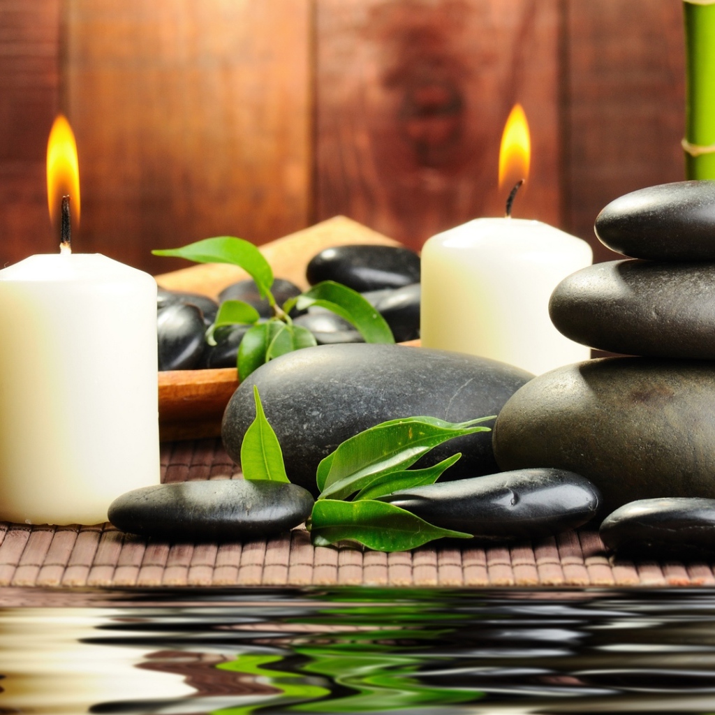 Черные камни дзен с двумя горящими свечами