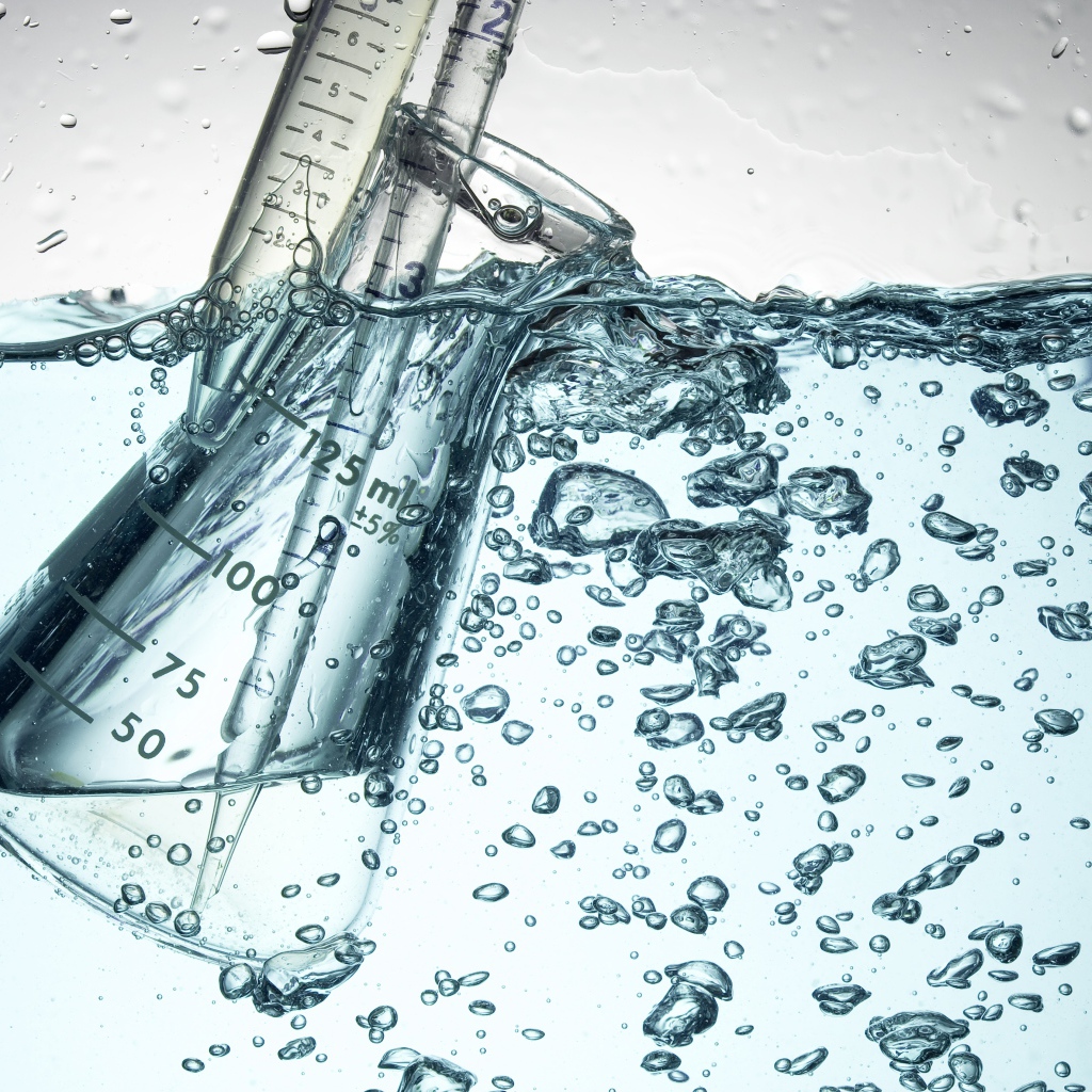 Измерительная чашка в воде с пузырями 