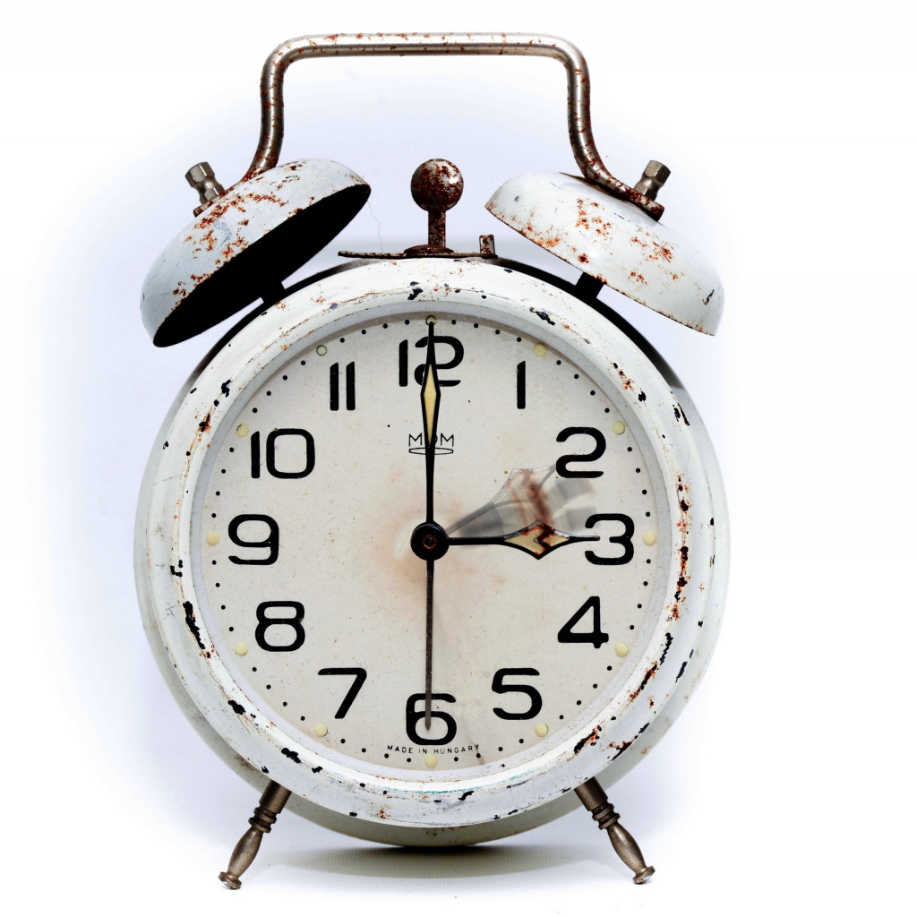 Старый будильник с большим циферблатом на белом фоне