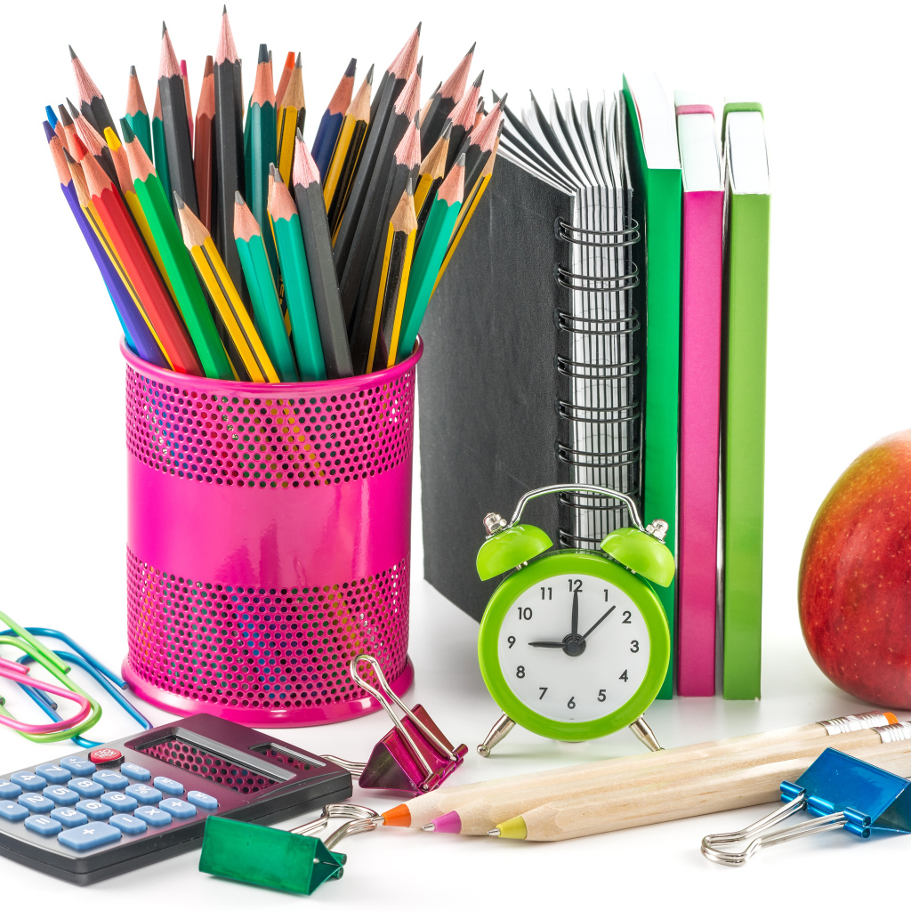 Канцелярские товары и красное яблоко на белом фоне