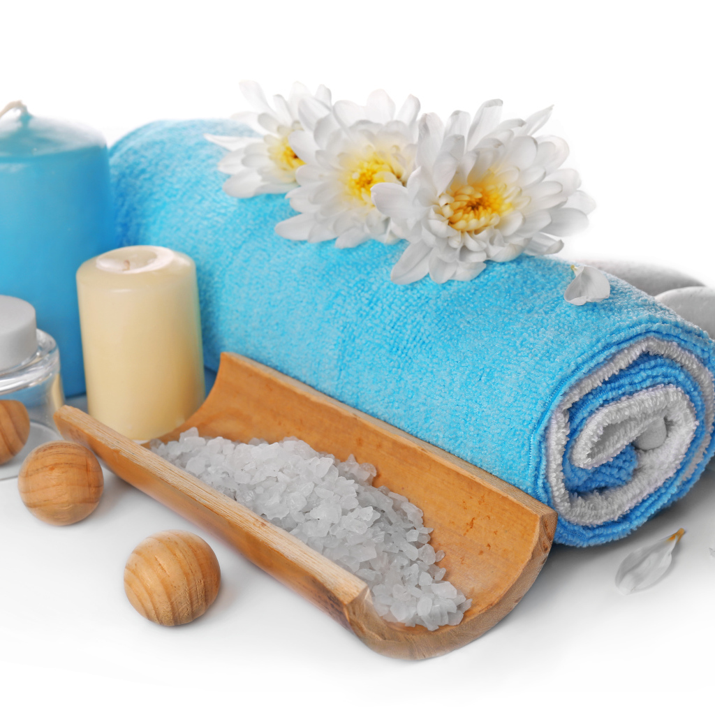 Полотенце, свечи, соль и цветы хризантемы на белом фоне