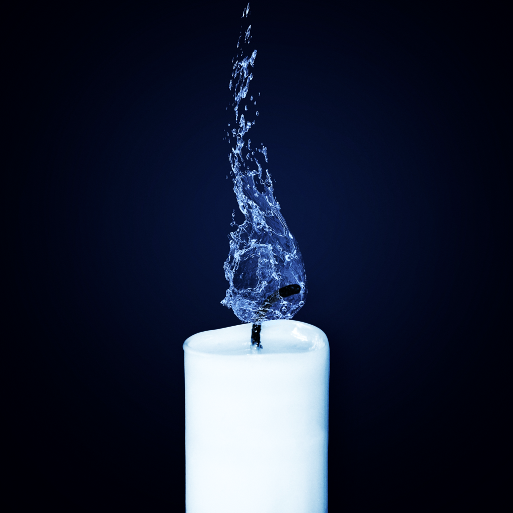 Белая свеча горит пламенем из голубой воды 