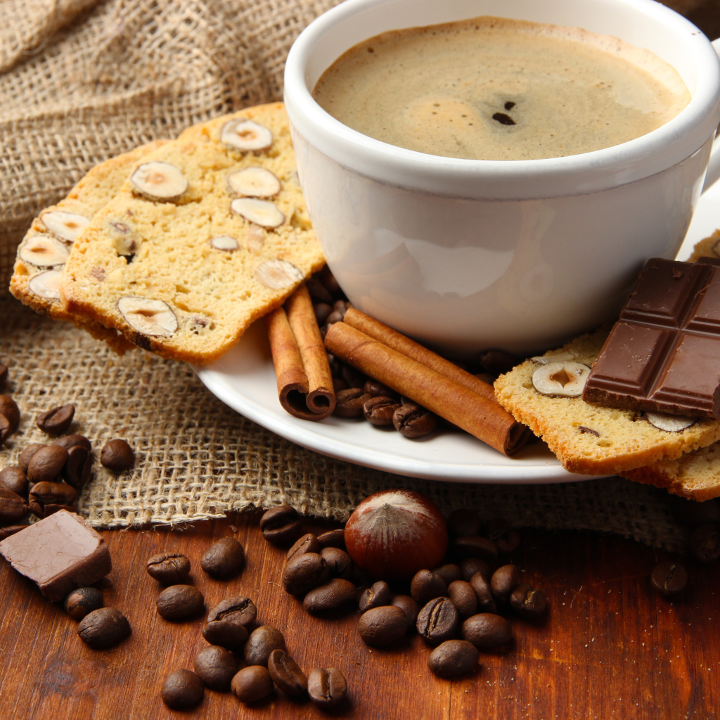 Чашка кофе с выпечкой, кофейными зернами и шоколадом