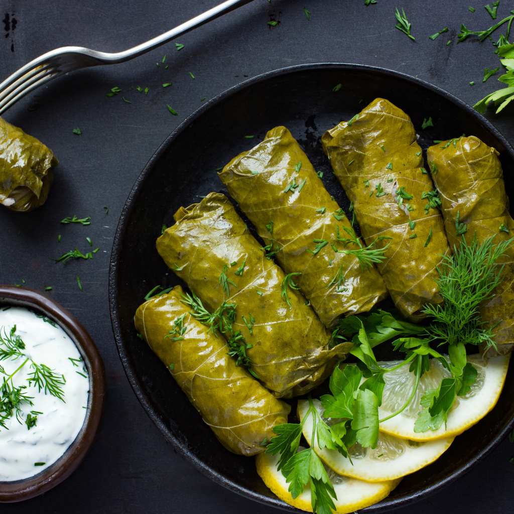 Аппетитная долма с кусочками лимона на столе 