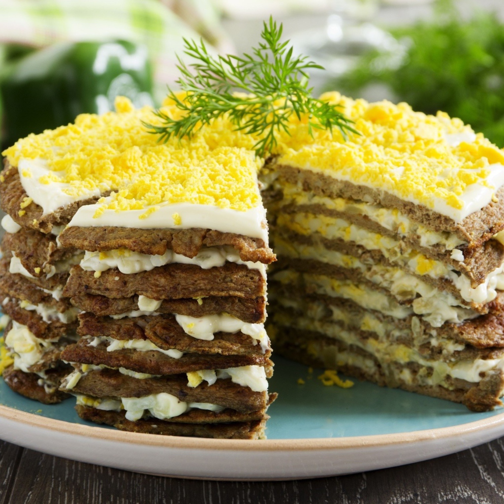 Аппетитный печеночный торт на блюде 