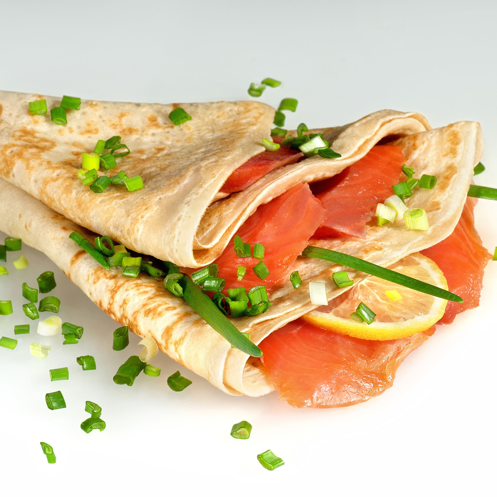 Аппетитный блин с красной рыбой и зеленым луком