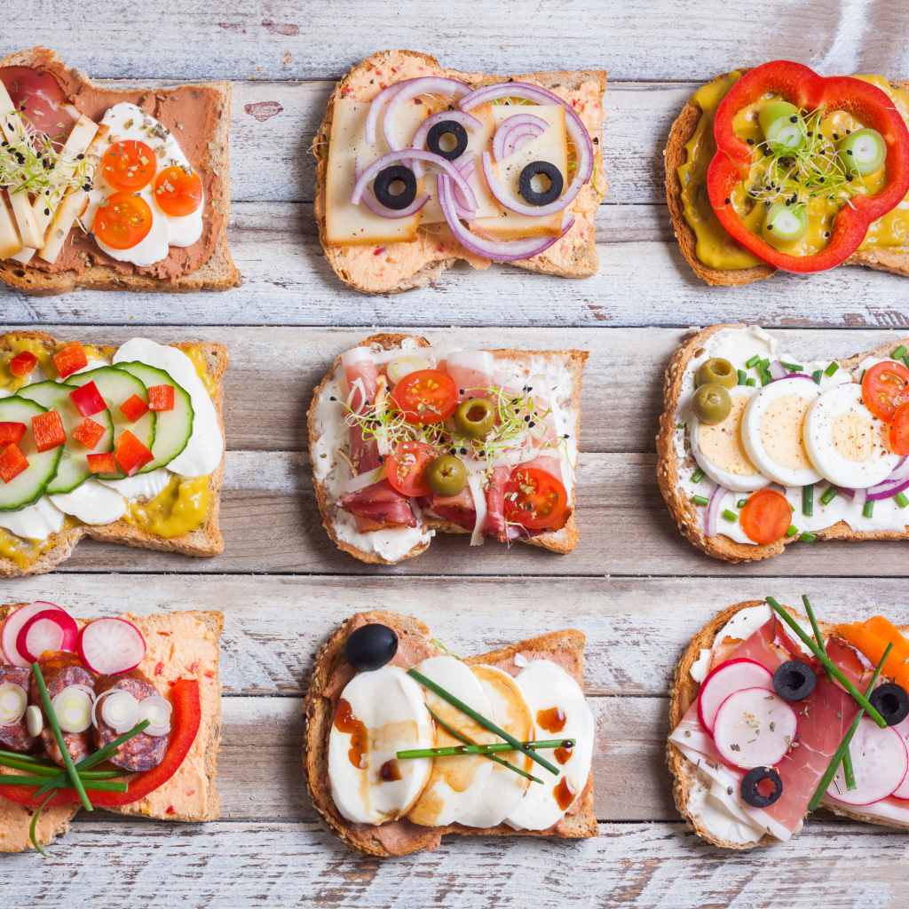 Аппетитные бутерброды на деревянном столе вид сверху