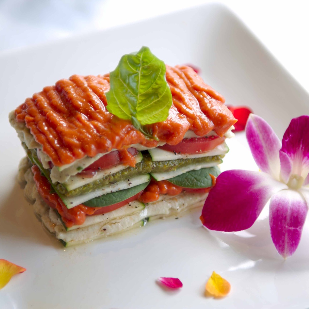 Аппетитный овощной бутерброд на белой тарелке с цветком