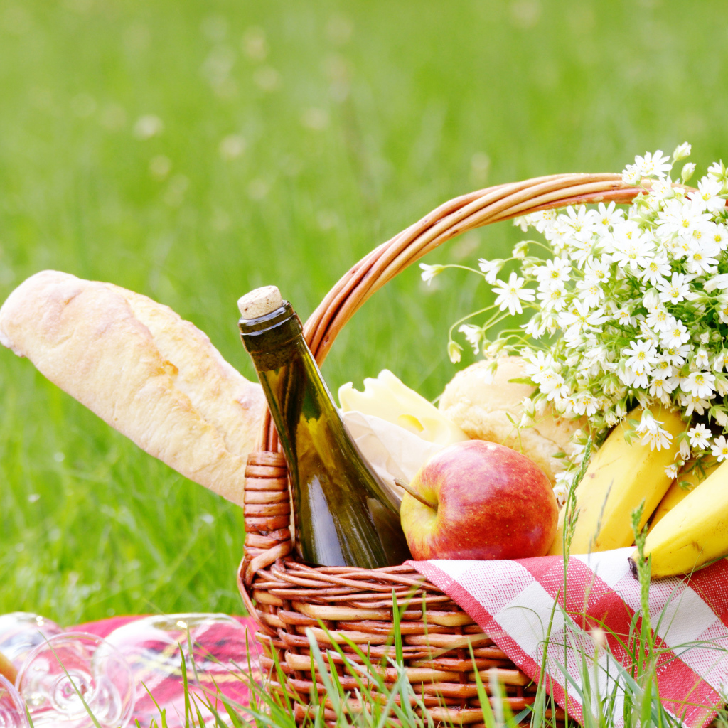 Корзина с продуктами для пикника и букетом белых ромашек