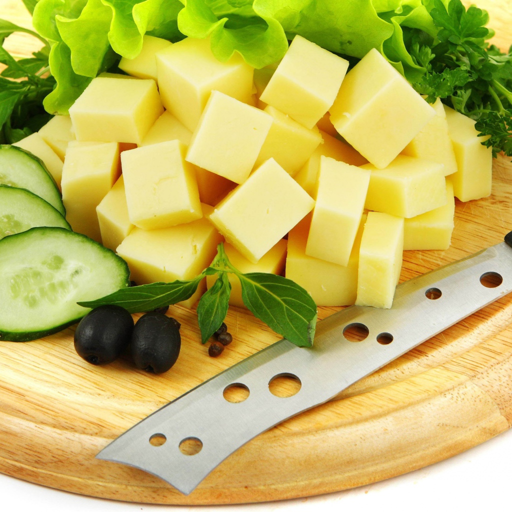 Сыр нарезанный кубиками на разделочной доске
