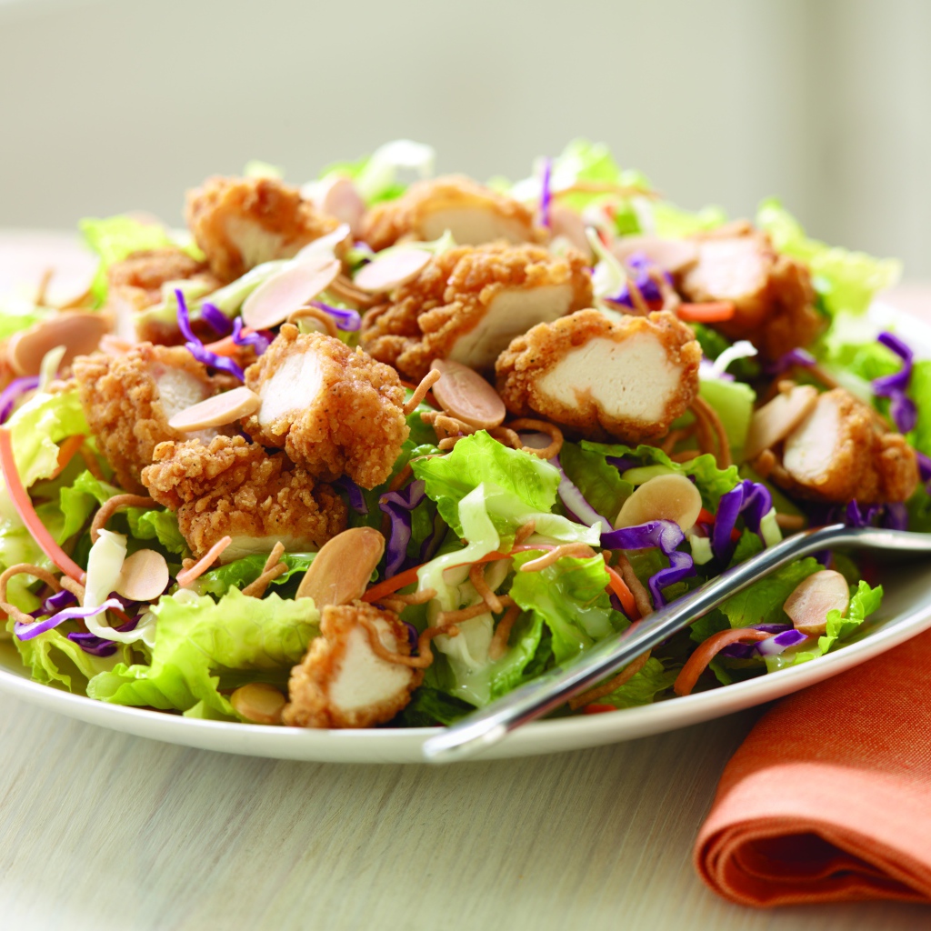 Куриный салат с орехами и капустой на тарелке