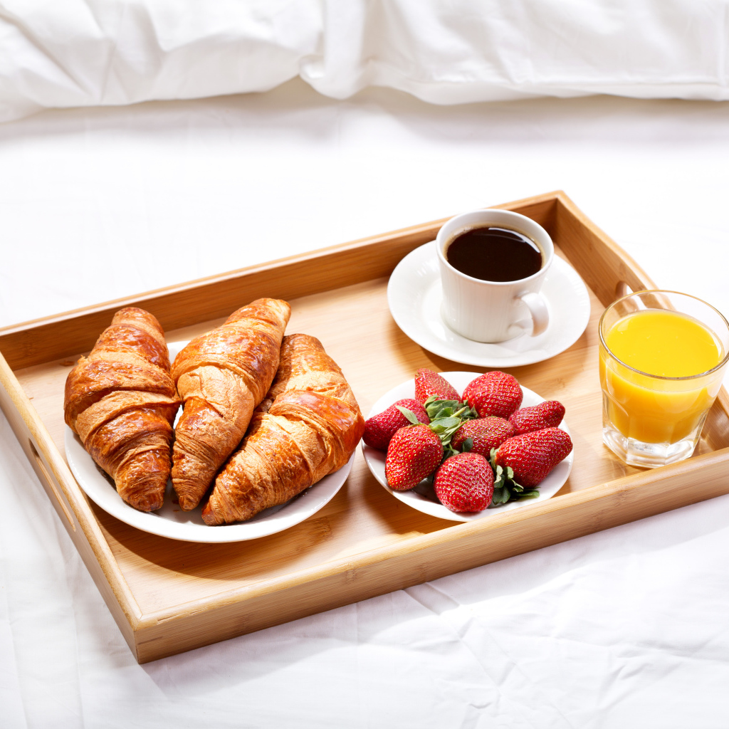 Круассаны, клубника, апельсиновый сок и кофе на завтрак