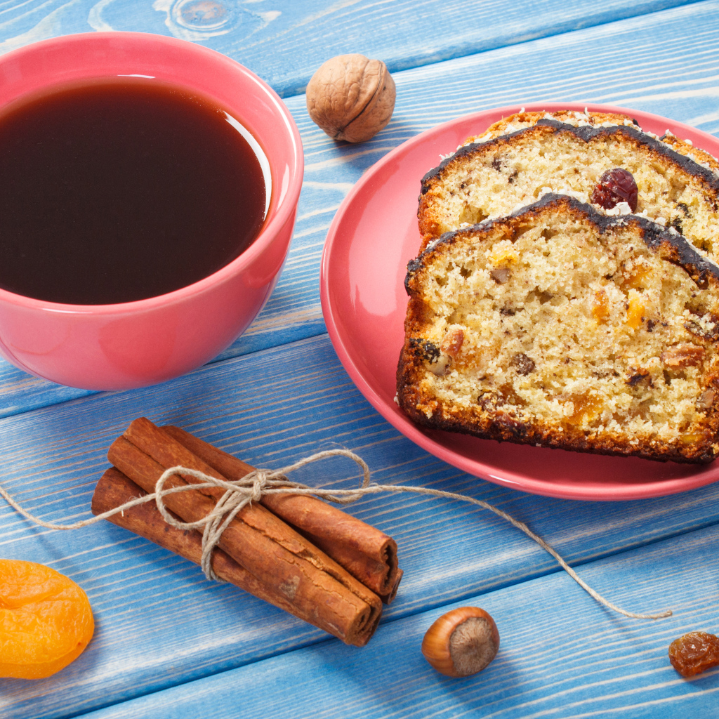 Кекс с корицей, орехами и курагой на столе с чашкой чая