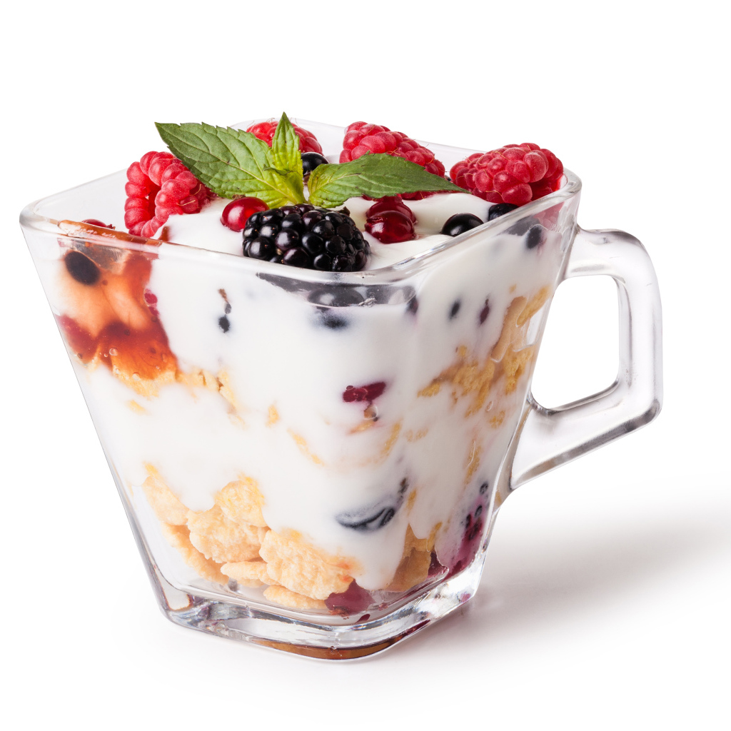 Хлопья с йогуртом и ягодами в стакане на белом фоне