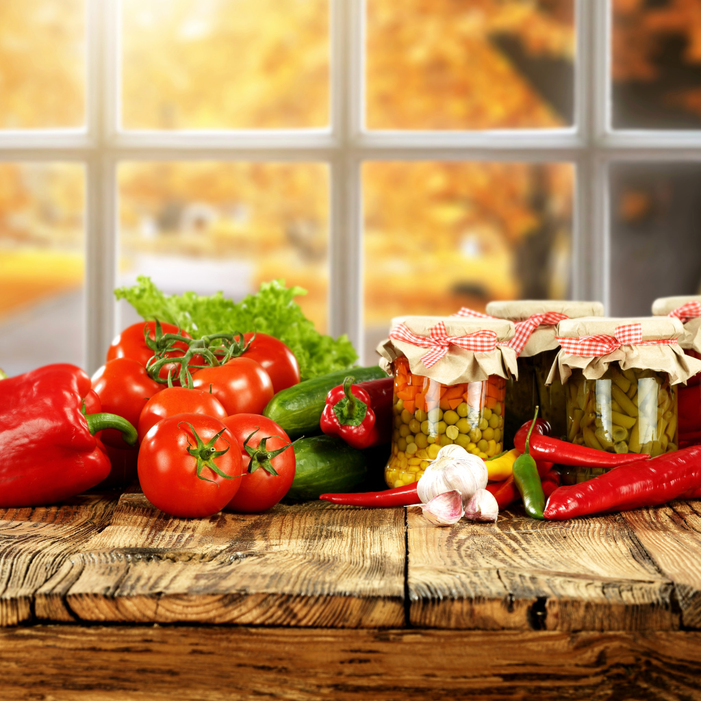 Свежие овощи и зимние заготовки на столе 