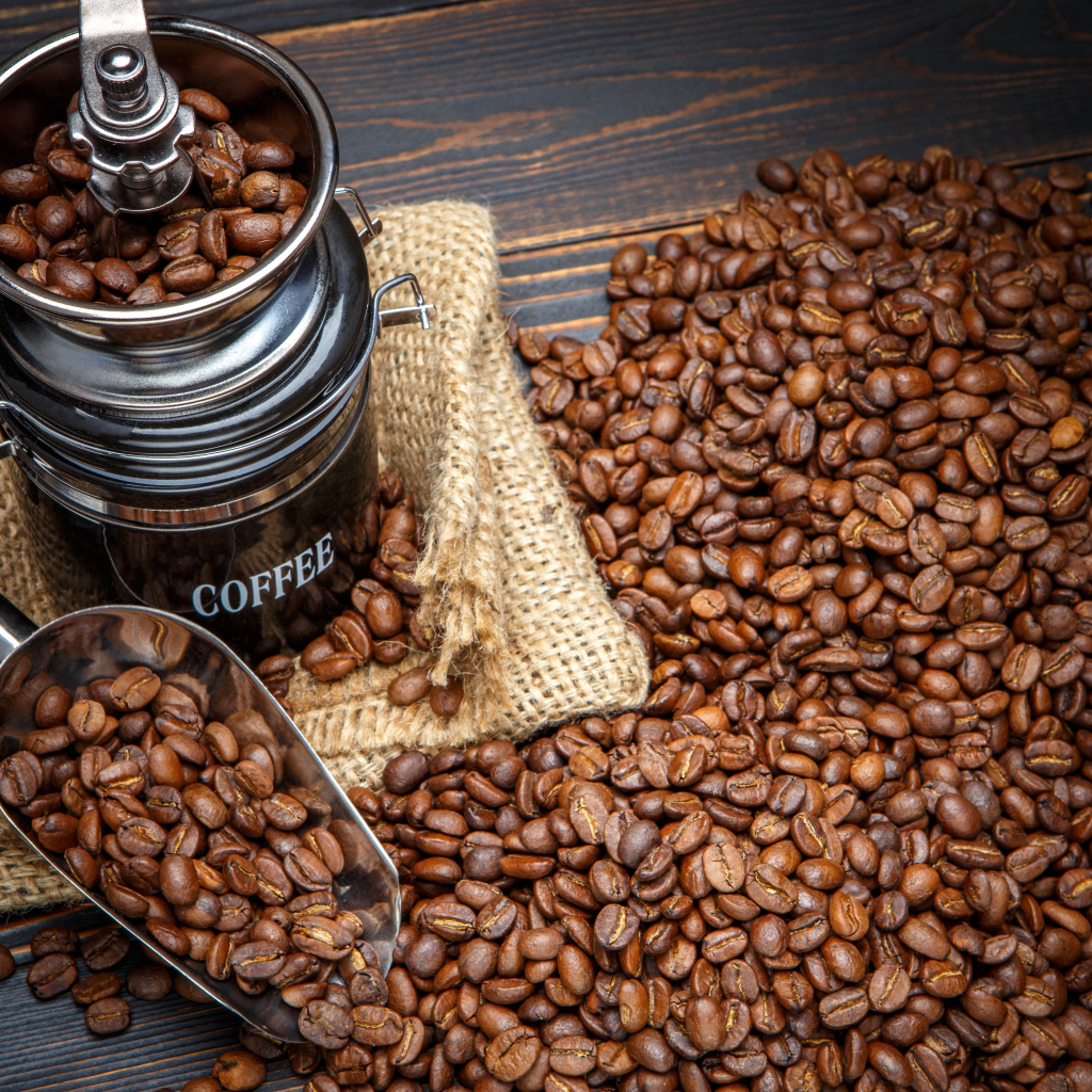 Жареные кофейные зерна с кофемолкой на столе