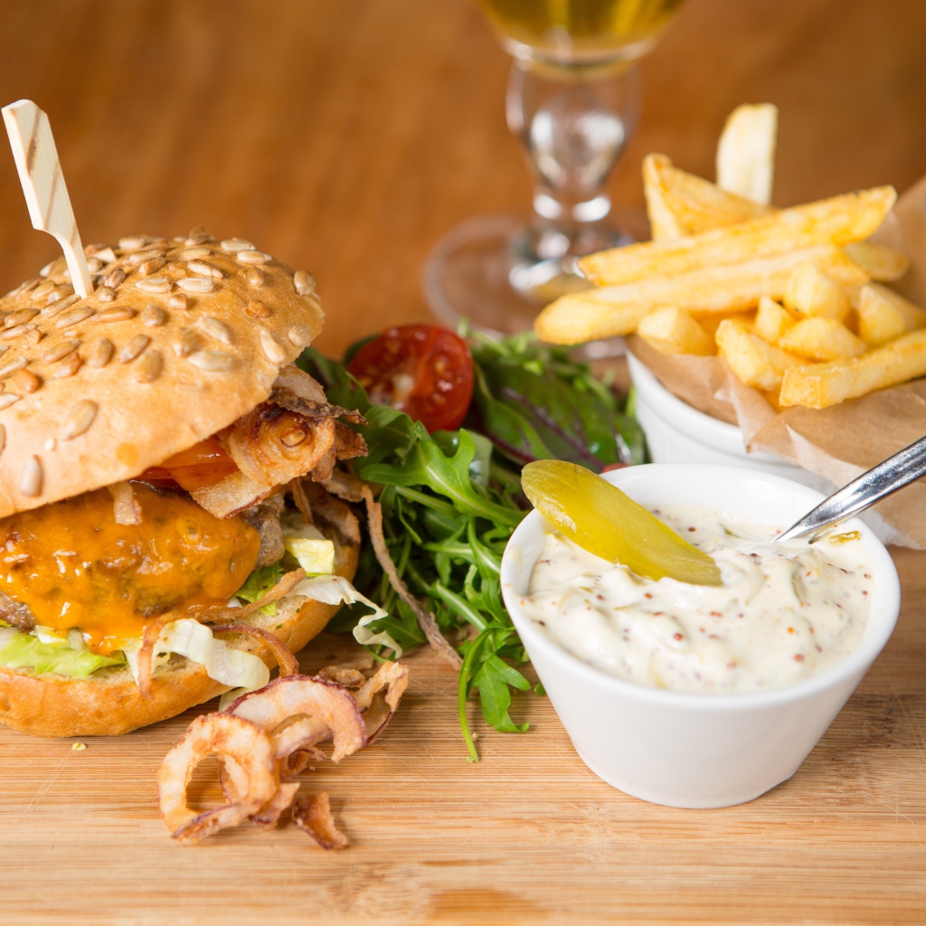 Гамбургер и картошка фри на столе с соусом