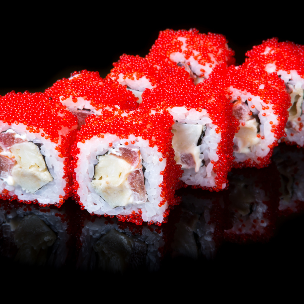 Японские роллы с красной икрой на черном фоне 