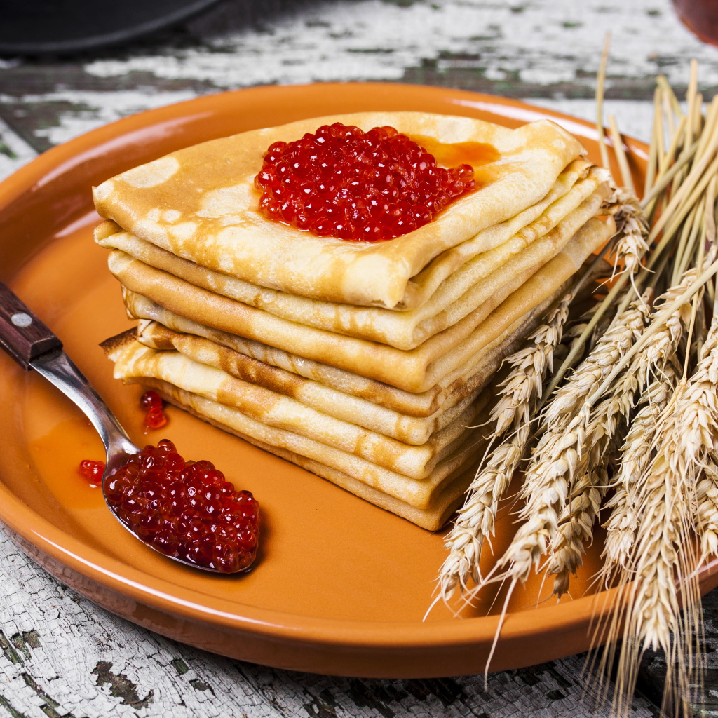 Блины с красной икрой и колосками пшеницы на тарелке