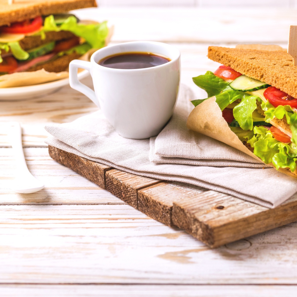 Сэндвич на столе с чашкой кофе на завтрак