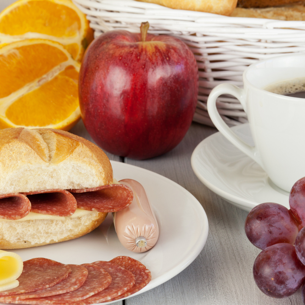 Бутерброд с сыром и колбасой и сок с яблоком и виноградом на завтрак