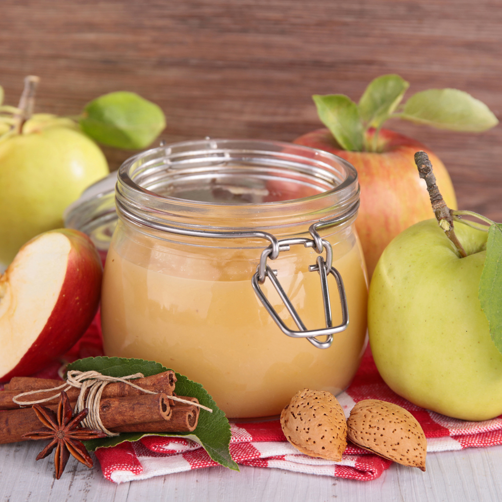 Банка яблочного джема с пряностями на столе