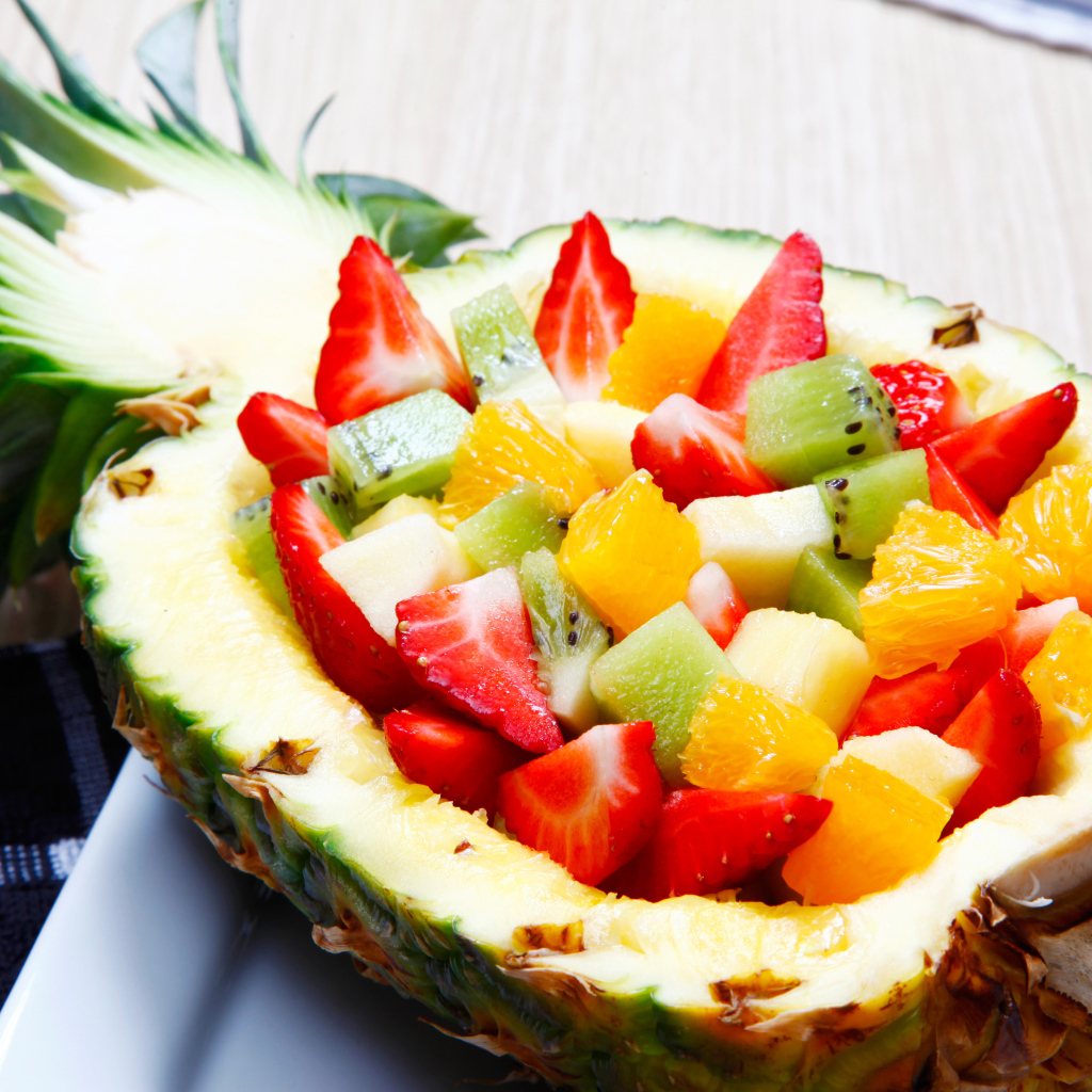 Фруктовый салат из цитрусовых  в тарелке из свежего ананаса 