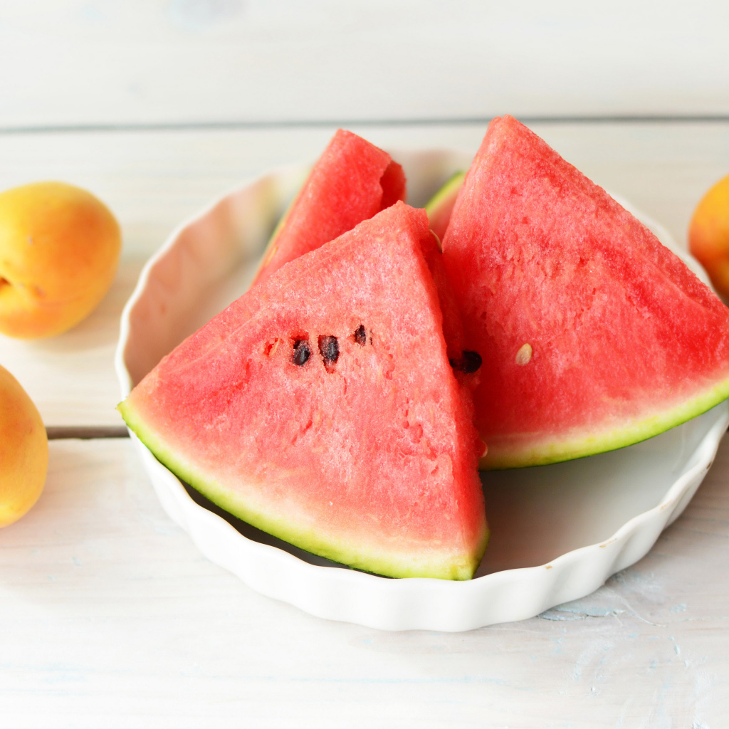 Кусочки сладкого арбуза с абрикосами на столе