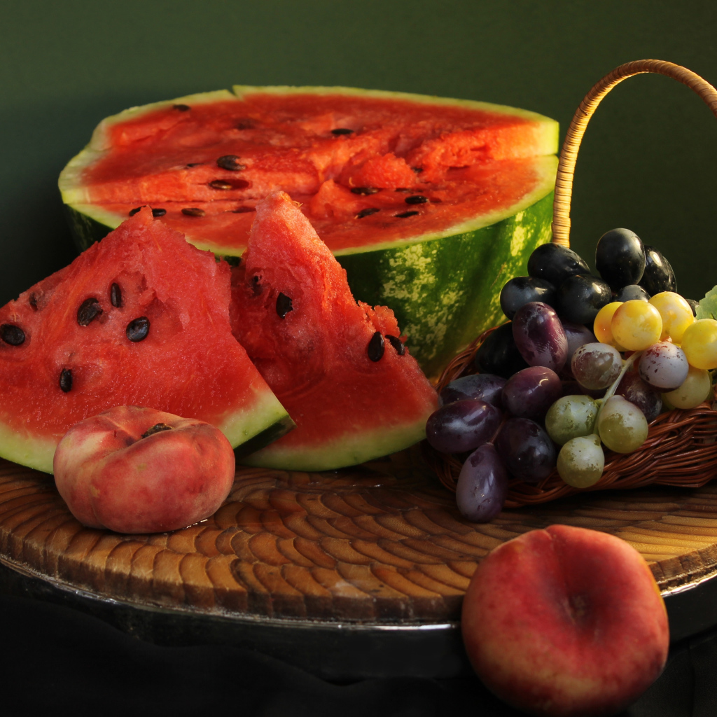 Нарезанный арбуз на столе с виноградом и персиками