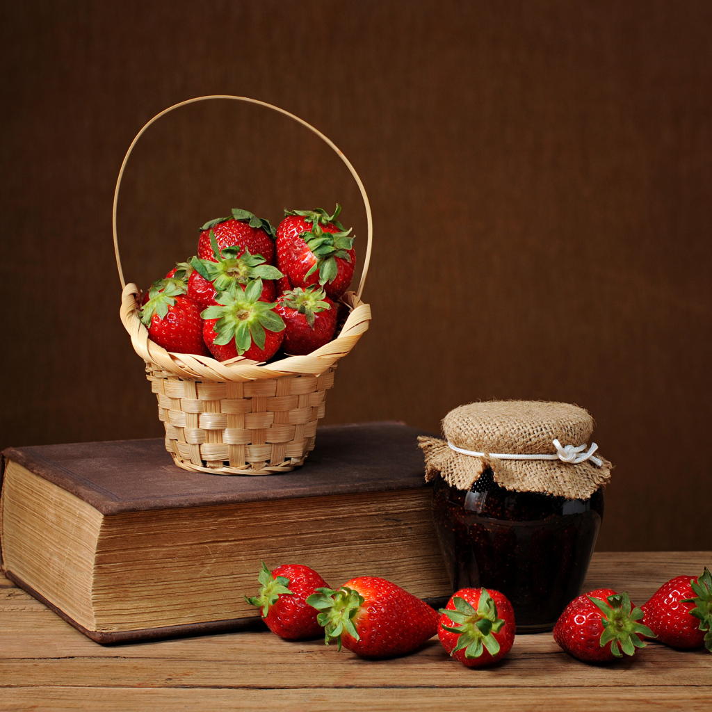 Клубничный джем, свежая клубника и книга на столе
